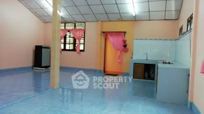 Spacious open layout kitchen with vibrant blue flooring and pink accents.