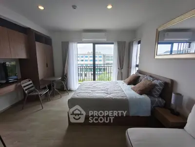 Spacious bedroom with modern decor and balcony view in a stylish apartment.