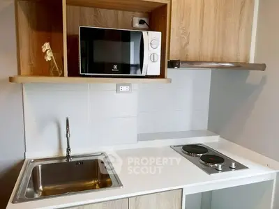 Modern kitchen with sleek countertop, built-in microwave, and electric stove.