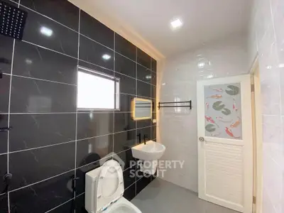 Modern bathroom with sleek black tiles and stylish fixtures