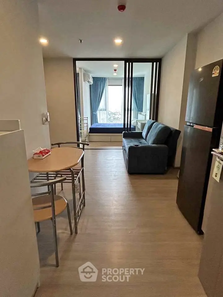Modern apartment interior with open layout, featuring a cozy living area and dining space.