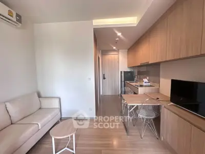 Modern living room with cozy sofa, sleek kitchen, and stylish dining area in open layout apartment.