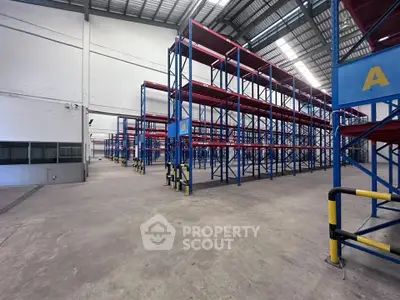 Spacious industrial warehouse with high ceilings and sturdy shelving units.