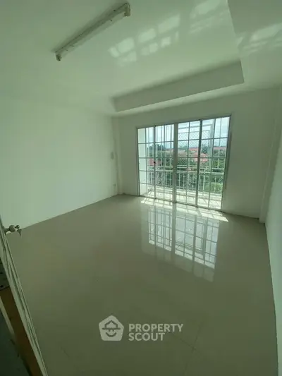 Spacious empty room with large windows and balcony view, perfect for customization.