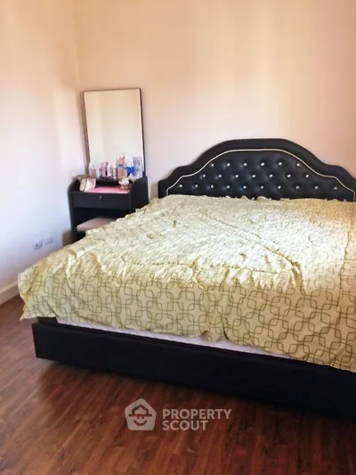 Cozy bedroom with elegant bed and wooden flooring, perfect for relaxation.