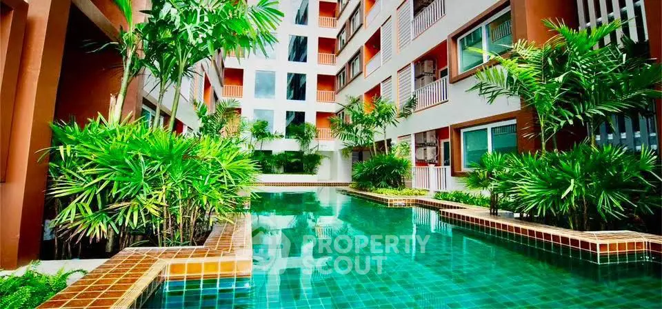 Luxurious apartment complex with stunning pool and lush greenery