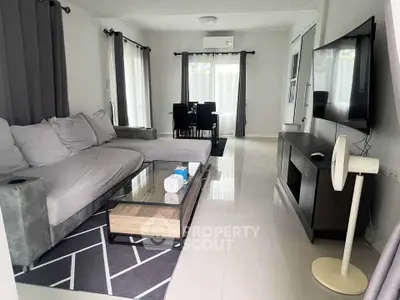 Modern living room with sleek furniture and large TV, perfect for relaxation.