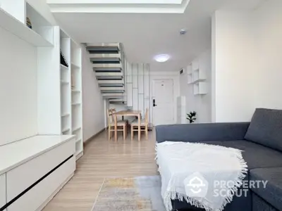 Modern living room with sleek staircase and cozy seating area