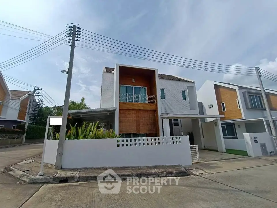 Modern two-story house with unique architectural design and spacious driveway in a suburban neighborhood.