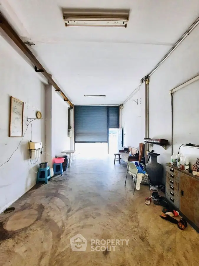Spacious storage area with roller door and minimal furnishings