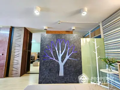 Modern living room with unique tree wall art and stylish lighting