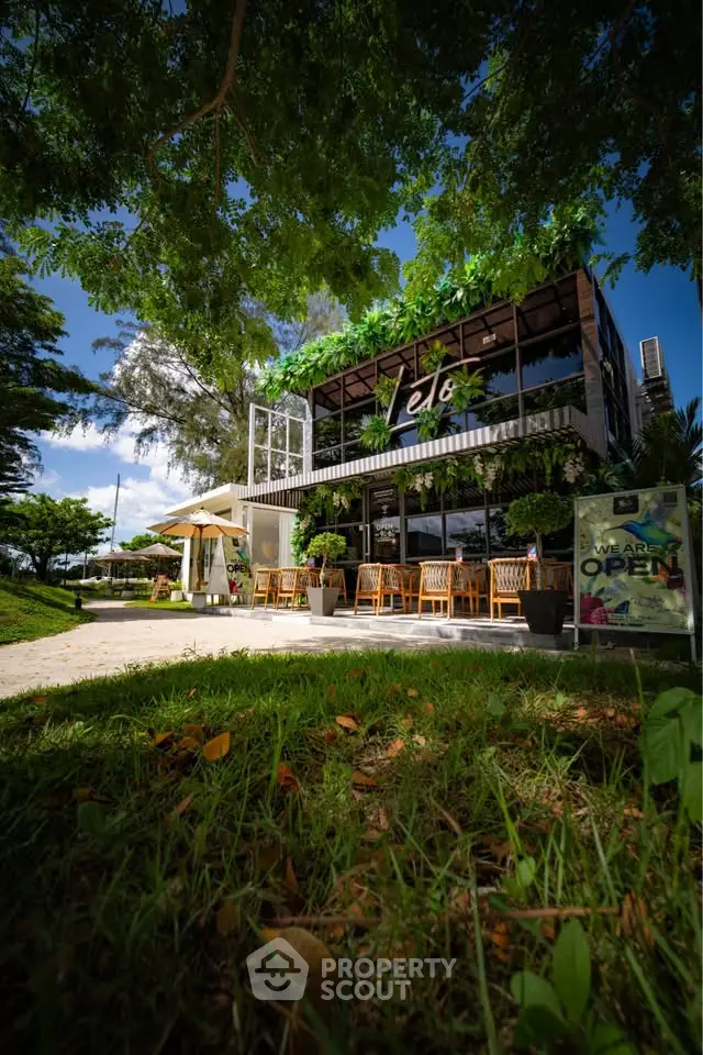 Charming cafe exterior with lush greenery and outdoor seating, perfect for a relaxing visit.