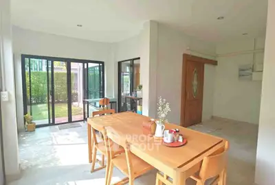 Bright dining area with wooden table and garden view, perfect for family gatherings.