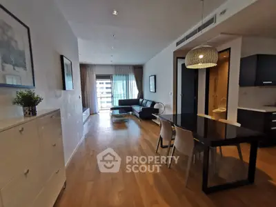 Spacious modern living room with dining area and large windows in a stylish apartment.