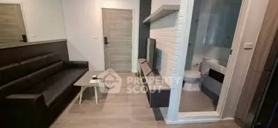 Modern compact living room with adjacent bathroom, featuring sleek design and neutral tones.