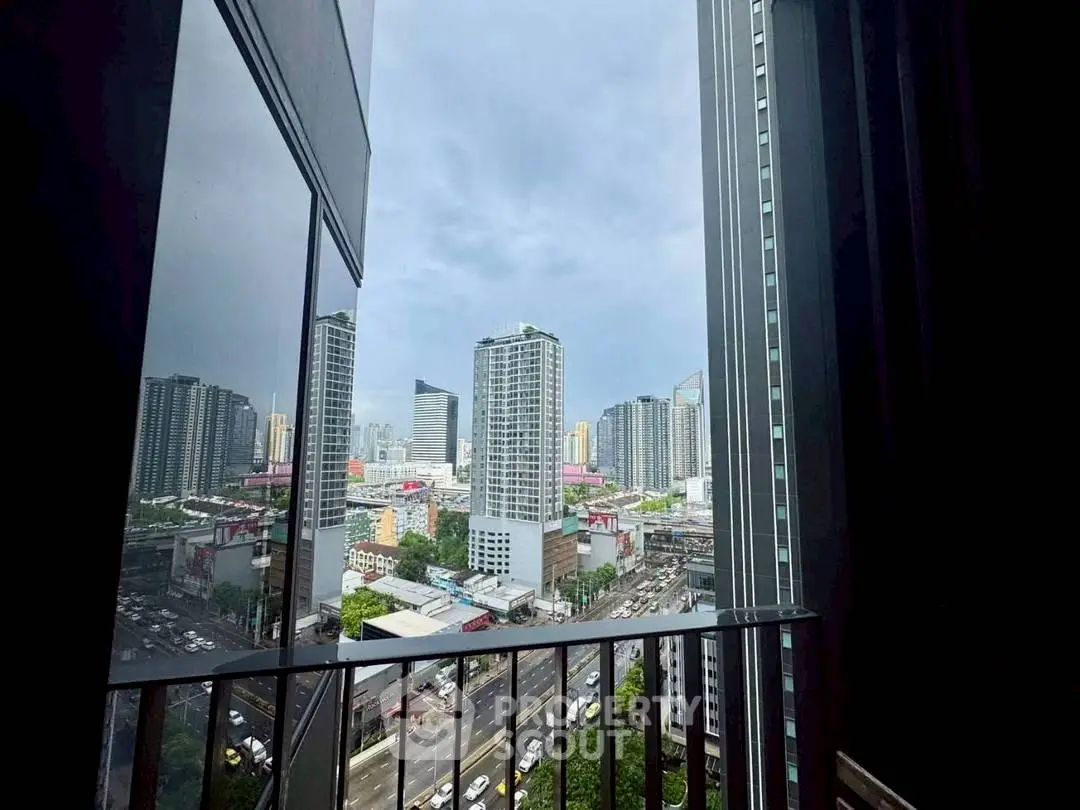 Stunning cityscape view from a high-rise balcony with modern skyscrapers and bustling streets.