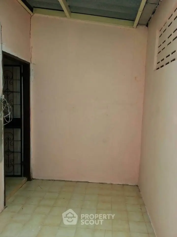 Cozy small room with tiled floor and open doorway, perfect for storage or utility use.