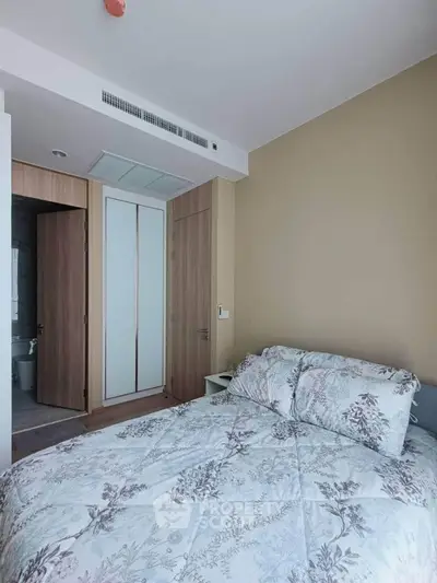 Cozy bedroom with floral bedding and wooden accents, featuring a modern en-suite bathroom.