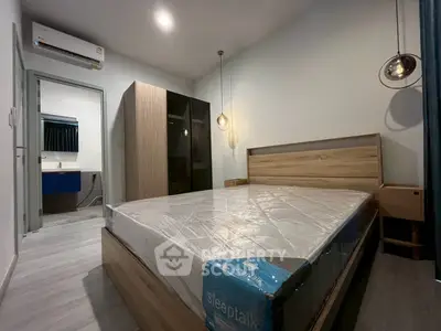 Modern bedroom with stylish lighting and sleek furniture, featuring a comfortable bed and spacious wardrobe.
