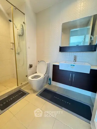 Modern bathroom with glass shower and sleek vanity in a contemporary apartment.