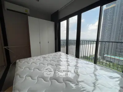 Modern bedroom with large windows offering stunning river and city views
