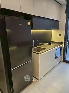 Modern kitchen with sleek cabinetry and built-in appliances in a compact layout.