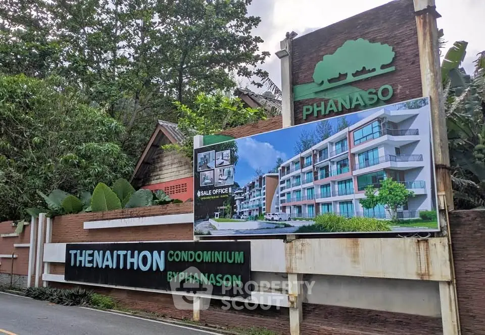 Modern condominium entrance with lush greenery and stylish signage at Phanaso Thenaithon.