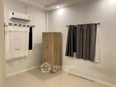 Cozy bedroom with air conditioning and stylish curtains, perfect for a comfortable living experience.
