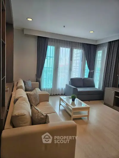 Spacious living room with modern decor and large windows in a stylish apartment.