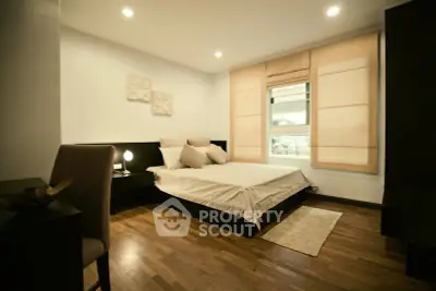 Elegant bedroom with wooden flooring and modern decor in a cozy apartment.