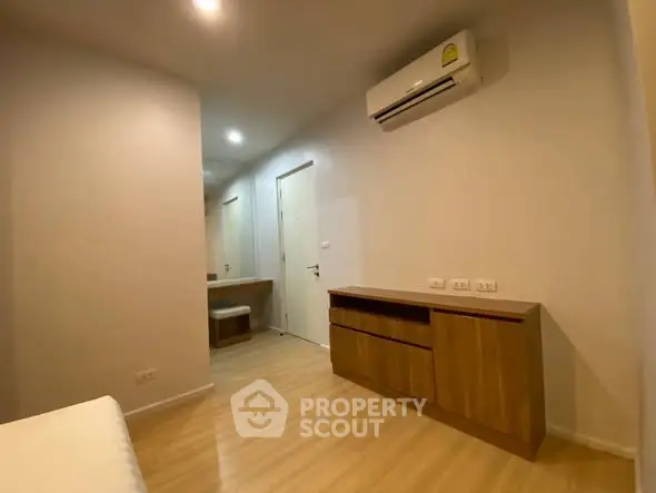 Modern bedroom with wooden flooring and air conditioning unit