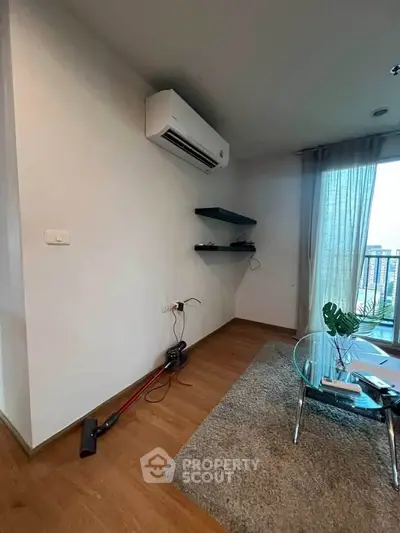 Modern living room with air conditioning and city view, featuring sleek glass table and cozy rug.