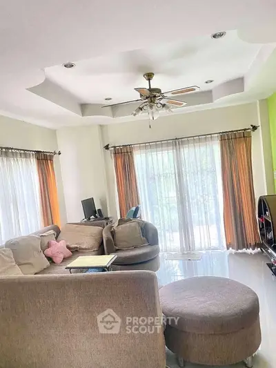 Spacious living room with elegant ceiling design and ample natural light