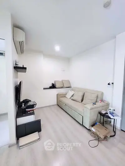 Modern living room with cozy sofa and sleek TV setup in a stylish apartment.