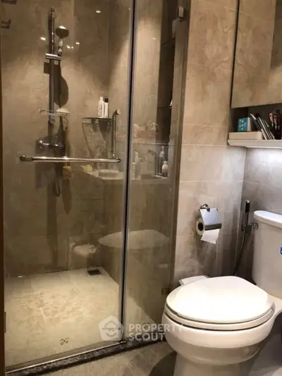 Modern bathroom with glass shower and sleek fixtures in a stylish apartment.