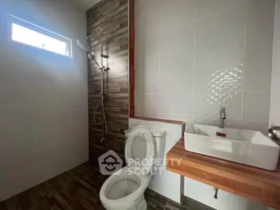Modern bathroom with sleek fixtures and natural light, featuring a stylish shower and contemporary sink design.