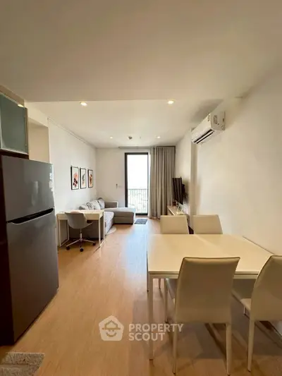 Modern living room with dining area and balcony access in a stylish apartment.