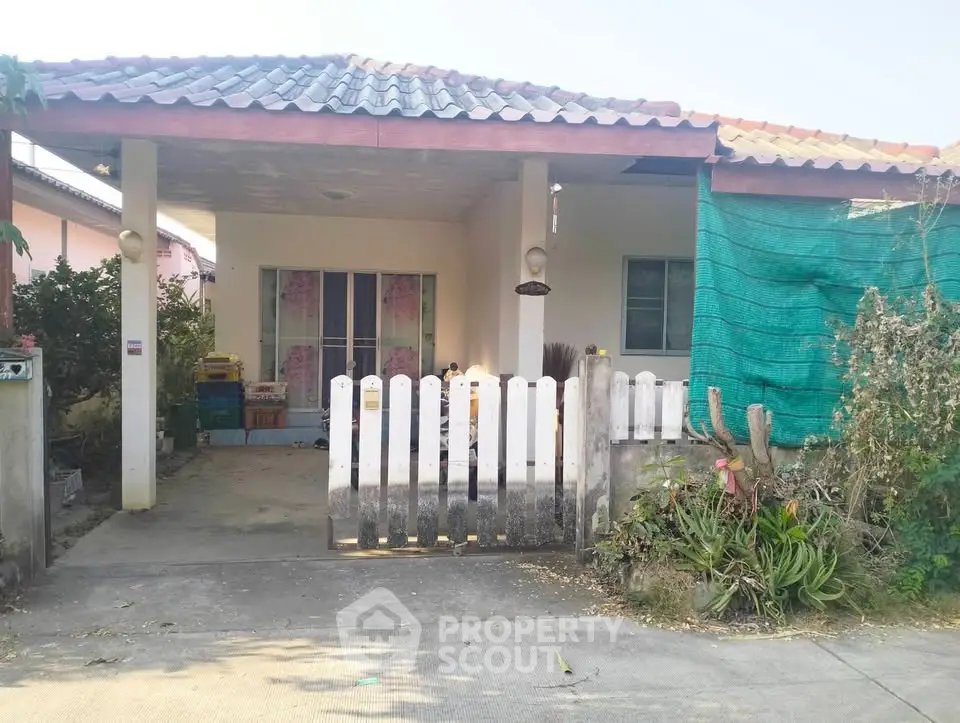 Charming single-story home with a cozy front porch and garden, perfect for family living.