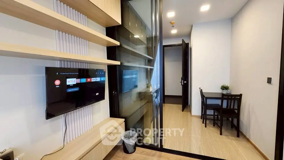 Modern apartment interior with sleek TV setup and cozy dining area