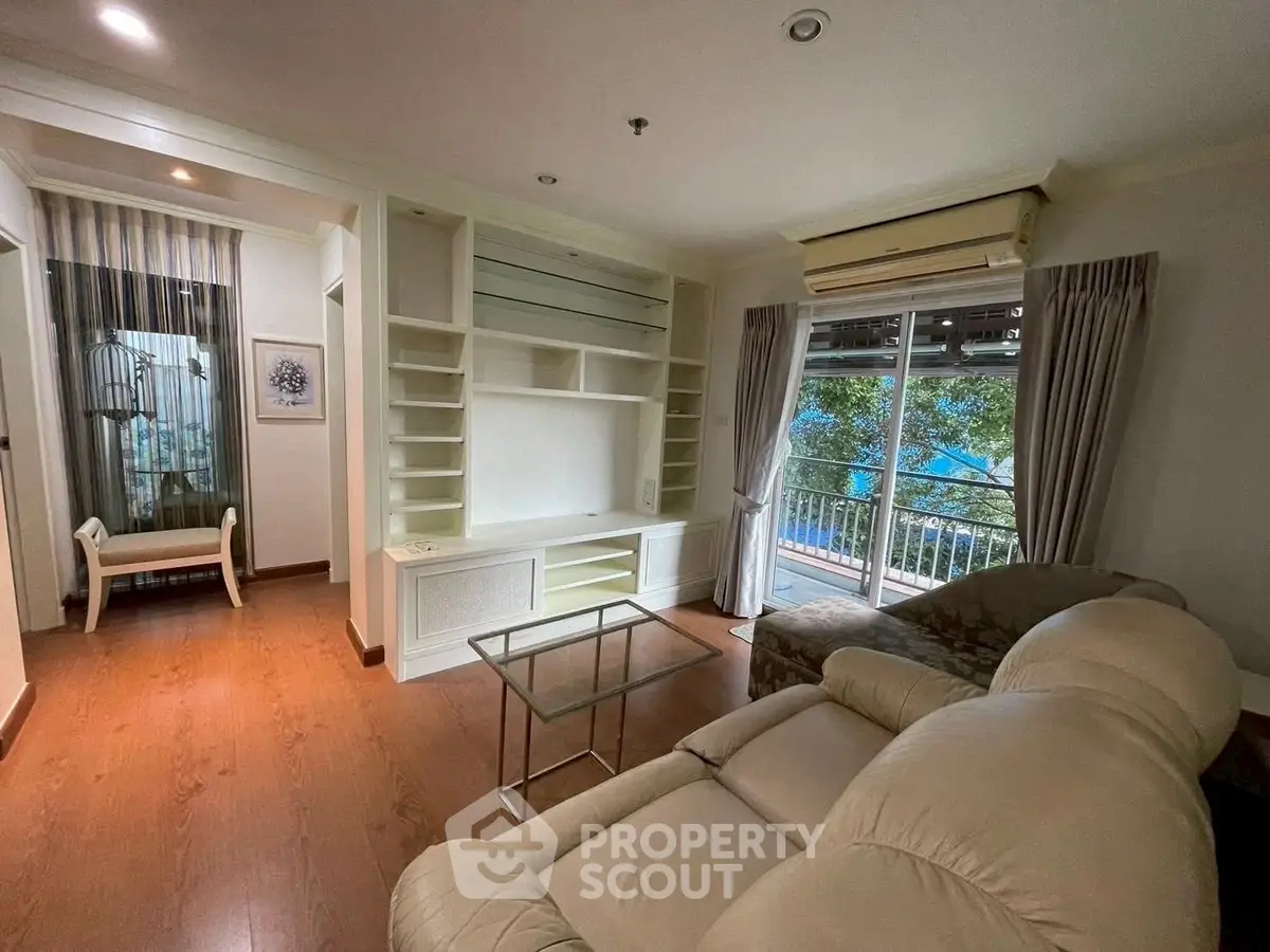Spacious living room with balcony and modern furnishings in a stylish apartment.