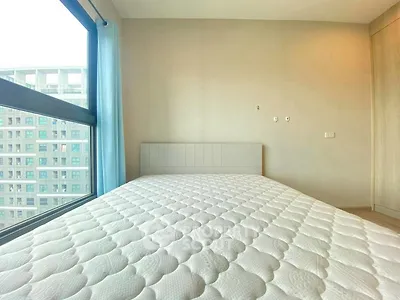 Spacious bedroom with large window and modern design in urban apartment