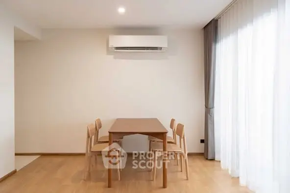 Modern dining area with wooden table and chairs under air conditioning unit