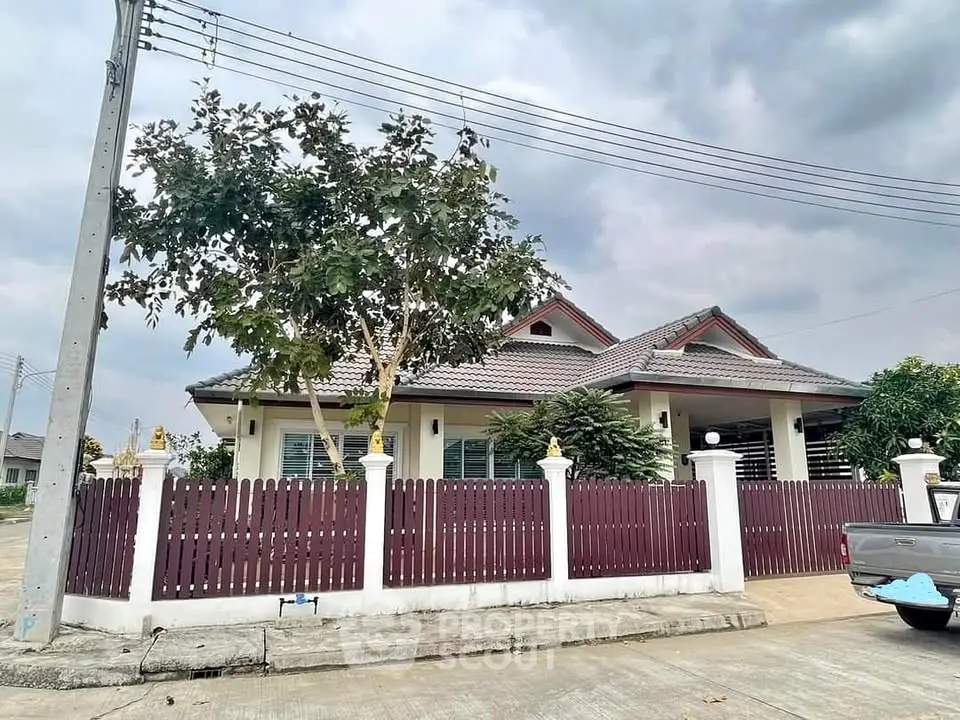 Charming suburban house with a fenced yard and lush greenery, perfect for family living.