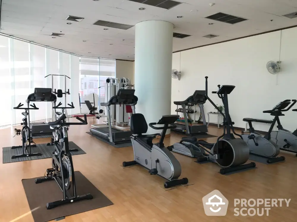 Spacious gym with modern exercise equipment and natural lighting