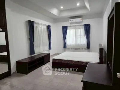 Spacious bedroom with modern furnishings and natural light