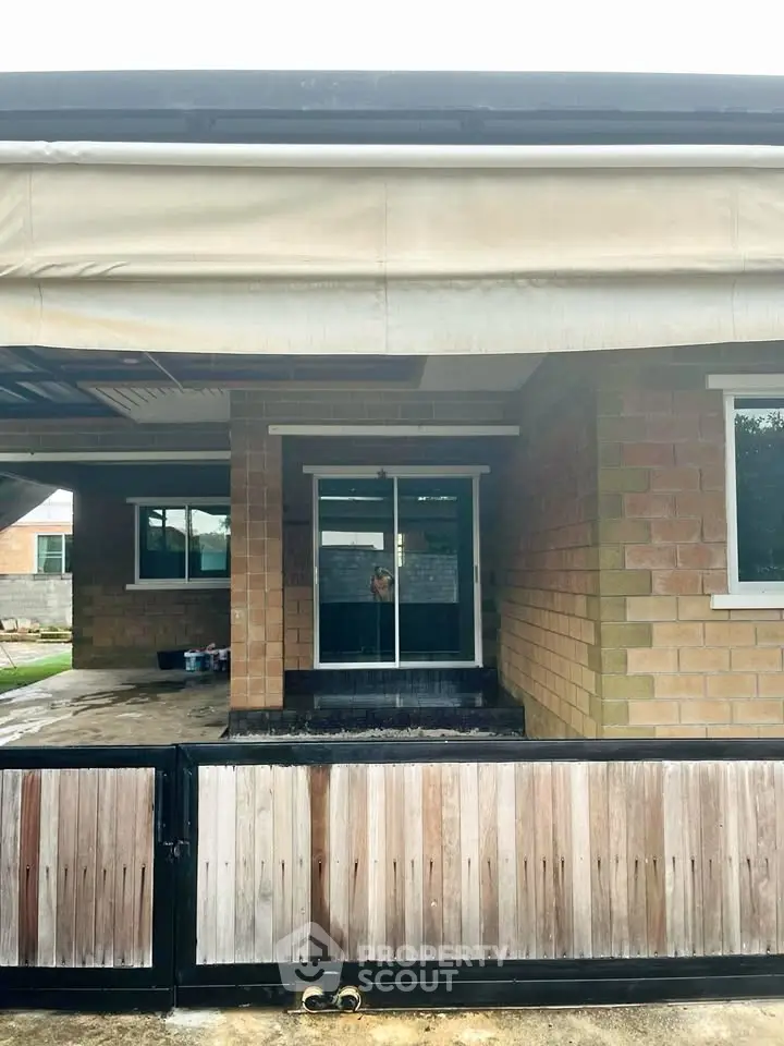 Charming brick home entrance with covered patio and secure gate