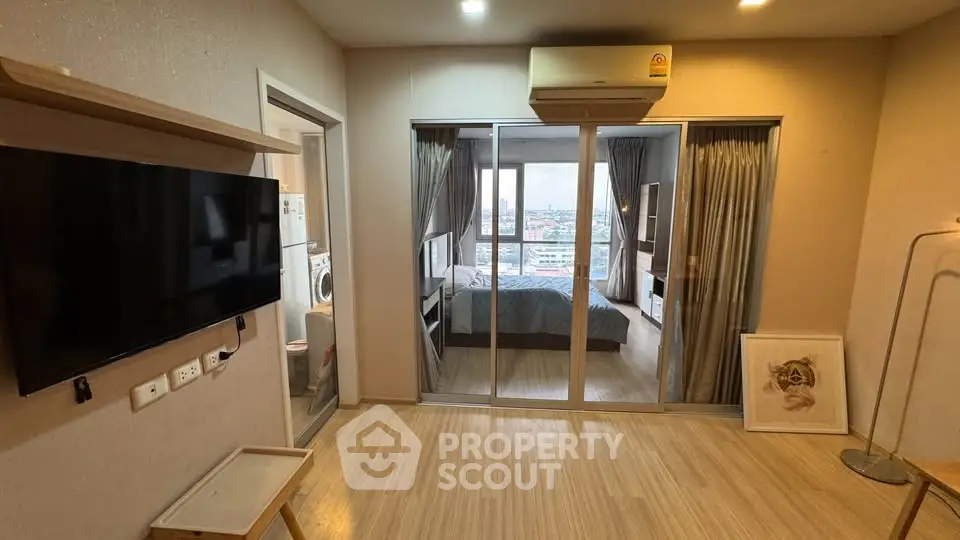 Modern apartment interior with bedroom view and wall-mounted TV, featuring sleek design and natural light.
