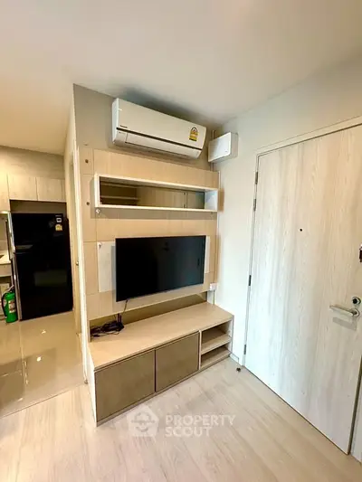 Modern living room with sleek TV setup and air conditioning in stylish apartment.