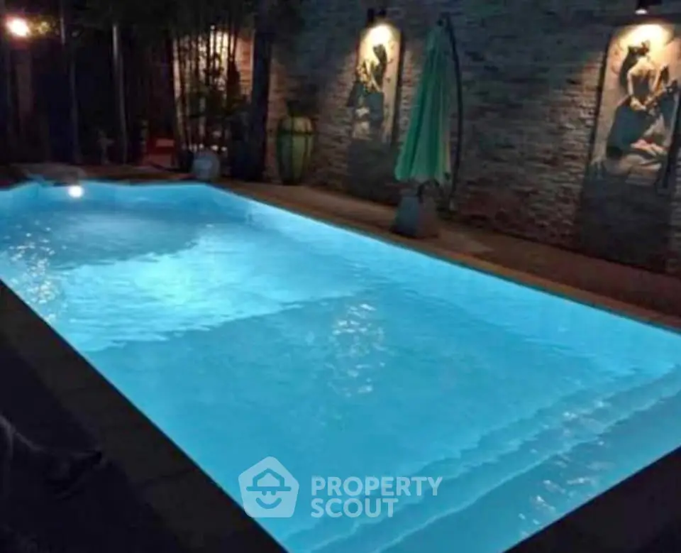 Luxurious illuminated swimming pool with ambient lighting and stylish decor, perfect for evening relaxation.