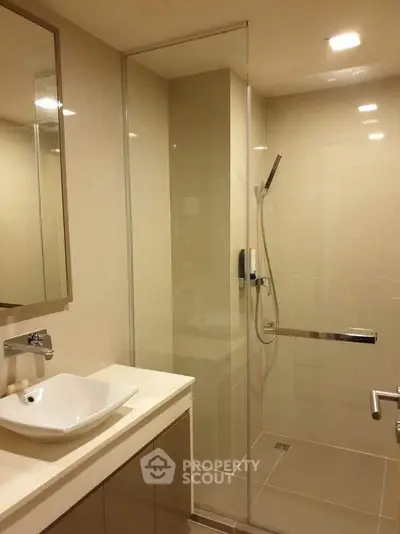 Modern bathroom with glass shower enclosure and sleek vanity